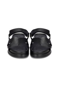 Sandales noires en cuir souple, au design ouvert, avec des brides larges, une boucle réglable et une semelle intérieure texturée pour le confort.