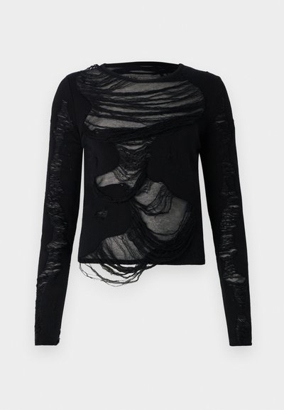 Melnā krekla ar garām piedurknēm, ar caurspīdīgām, plīšanas sekcijām un teksturētām rakstām, ar apaļu apkakli un nevienmērīgiem iedobumiem visā kreklā.