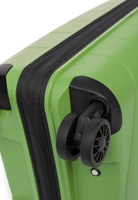 Zelený kufr s tvrdou skořepinou a texturovaným povrchem, černým zipem a dvojitými kolečky. Vyznačuje se hladkým, zakřiveným designem a zesílenými okraji.