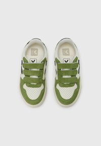Πράσινα και λευκά αθλητικά παπούτσια από σουέντ και διάτρητο δέρμα, με τρεις ιμάντες βέλκρο και μαύρες λεπτομέρειες. Επίπεδη λαστιχένια σόλα.