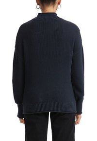Navyblauwe gebreide trui met een ribbelachtige ronde halslijn en een gestructureerd lichaam. Losse pasvorm met verlaagde schouders en ribgebreide mouwen en zoom.