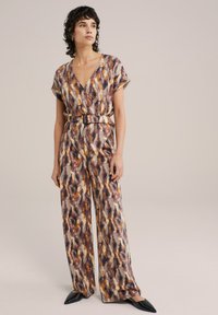 Tuta multicolore con scollatura a V profonda, maniche corte, vita cintata e gambe ampie, caratterizzato da un audace motivo astratto in tonalità calde.