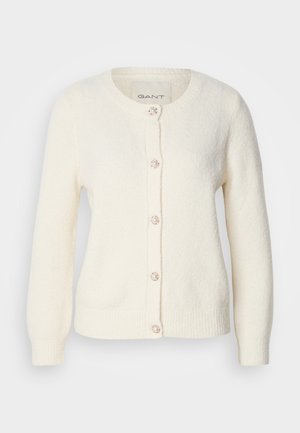 Kermainen villatakki pitkillä hihoilla, pyöreällä kaula-aukolla, tekstuurilla, viidellä nappilla, joissa on helmimäiset yksityiskohdat, sekä kahdella etutaskulla.