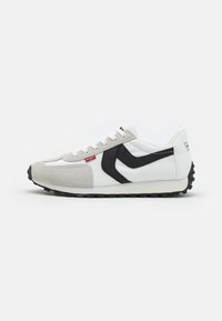 Weiße und graue Sportschuhe mit schwarzem Akzent, strukturierten Wildleder- und Mesh-Obermaterial, Schnürdesign und einem strukturierten Gummisohle.