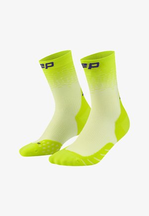 Leuchtend gelb-grüne Sportsocken mit hellem Verlaufsmuster, gerippter Textur und kleinen Logos nahe dem Bund und den Zehenbereichen.