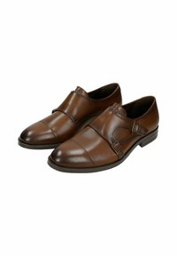 Scarpe in pelle marrone caratterizzate da un design elegante, dettagli con doppia fibbia, punta arrotondata e una leggera lucentezza su una suola piatta.