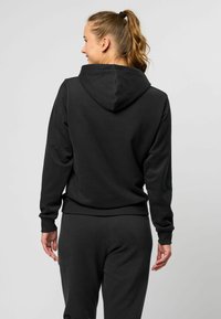Zwarte hoodie met een ontspannen pasvorm, geribbelde manchetten en een geribbelde tailleband. De stof lijkt zacht en glad, met een eenvoudig ontwerp.
