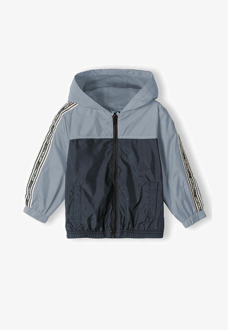 Lightweight, hooded windbreaker in blue and navy. Features a front zipper, elastic cuffs, and side pockets with contrasting side stripes.