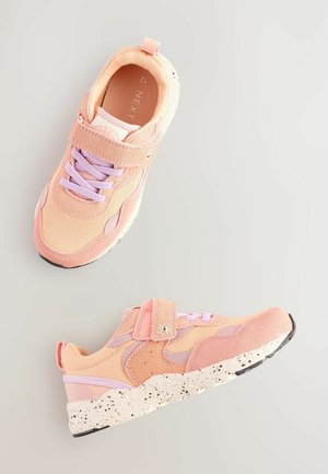 Rosa sportskor med en kombination av slät och texturerad tyg, med pastellfärgade snören, en kardborrerem och en prickig sula.