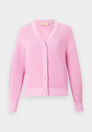 Šviesiai rožinė megztinė su tekstūrinio mezgimo medžiaga, su V formos iškirpte, priekiniais mygtukais ir grublėtomis rankovėmis. Klasikinis ir universalus dizainas.