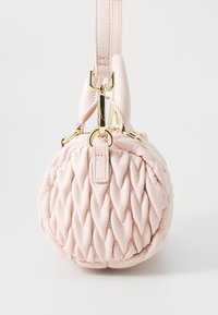 Round pink leather handbag with a quilted design, featuring a gold hardware strap and a top handle. Smooth texture and seamless finish.