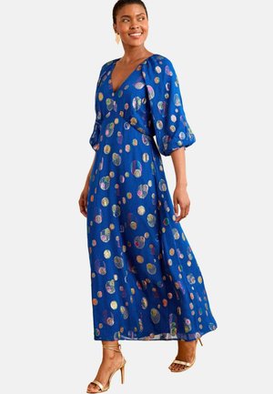 Blue maxi dress with a deep V-neck and puff sleeves, featuring a multicolored polka dot pattern. Lightweight, flowing fabric; ankle length.