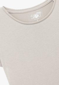 T-shirt corto a maniche corte beige chiaro con scollo rotondo, realizzato in tessuto morbido, con un'etichetta che riporta 'Koton SPORT', taglia S.