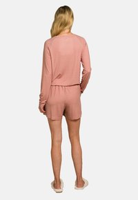 Langärmliges, rosa Schlafanzug-Set mit geometrischem Muster, versehen mit einem elastischen Bund und passenden Shorts, aus weichem, leichtem Stoff gefertigt.