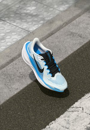 Baskets de course bleu clair avec des accents noirs, tige en mesh, lacets noirs et semelle blanche. Design texturé avec un logo sur le côté.