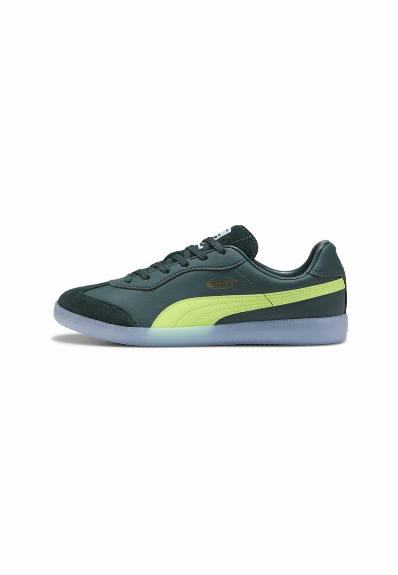 Roheline nahast tennis鞋 lime roheliste aktsentidega, sametist toe cap, mustad paelad ja läbipaistev kummist tald. Omab brändimist küljel.