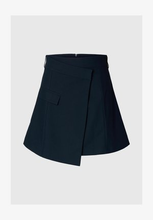 Tengerészkék átlapolós mini szoknya oldalsó zsebfedővel és rejtett hátsó cipzárral, egyszínű háttéren.