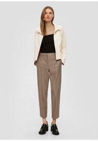 Crème, gestructureerde blazer met een staande kraag, gecombineerd met lichtbruine, op maat gemaakte broek en zwarte loafers. Gladde texturen en modern design.