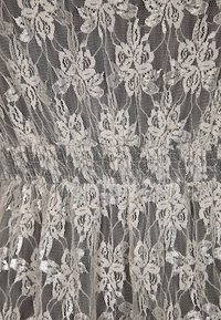 Spitzenstoff in hellem Beige mit Blumendrucken, der eine gerüschte Taille für die Raffungen und eine weiche, zarte Textur aufweist.