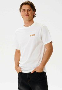 Hvid bomuld t-shirt med korte ærmer, der har et lille orange "RIP CURL" logo på venstre bryst. Standard crewneck-design.