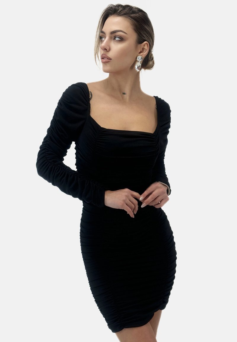 Schwarzes gerafftes Kleid mit langen Ärmeln, quadratischem Ausschnitt und strukturiertem Stoff. Figurbetonter Stil mit horizontalen Falten im gesamten Kleid.