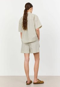 Beige striped short-sleeve shirt and matching shorts, featuring vertical stripes in dark brown, with a relaxed fit and back view.