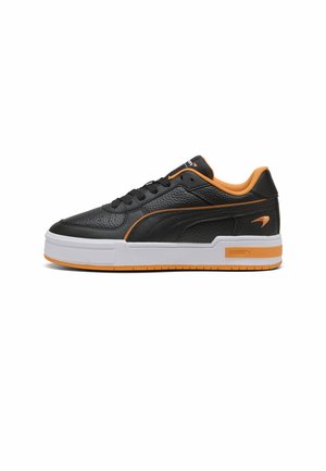 Czarny skórzany niski sneaker z pomarańczowymi akcentami i białą podeszwą, o fakturowanym wzorze i zapięciem na sznurówki.
