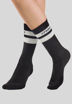 Schwarze, gerippte Socken mit einem weißen gestreiften Band oben, versehen mit bedruckten Buchstaben. Weiche Textur und knöchellanges Design.