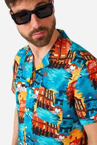 Camicia a maniche corte con bottoni che presenta uno sfondo blu vivace con un intricato motivo di edifici, persone e accenti grafici.