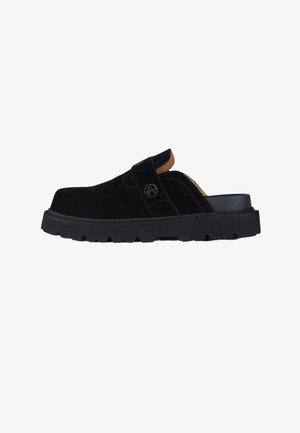 Zoccoli in camoscio nero slip-on con suola spessa scolpita e cinturino laterale con logo circolare "A".