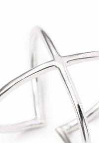 Silberring mit sich kreuzenden, glatten Bändern und polierter Oberfläche, der eine abstrakte Sternform erzeugt. Minimalistisches und elegantes Design.