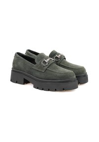 Grüne Wildleder-Pantoletten mit einer massiven schwarzen Gummisohle, die metallene Hardware-Akzente und ein klassisches Mokassindesign aufweisen.