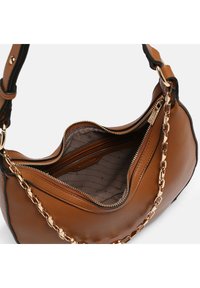 Sac à main en cuir marron texturé avec une chaîne dorée et une fermeture éclair partiellement ouverte révélant une poche intérieure doublée.