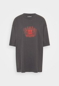 Šedé bavlněné tričko s volným střihem, na přední straně s potiskem červeného erbu. Klasický kulatý výstřih a krátké rukávy.