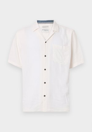 Trumpas rankovės marškinys, pagamintas iš lengvo audinio, kreminės spalvos, su krūtinės kišene ir juodais mygtukais prie priekinės sagos.