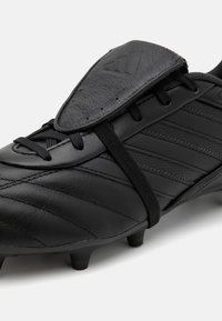 Crampons de football noirs en cuir texturé avec des rayures horizontales distinctes et un design à lacets. Comprend un rabat de protection et des crampons moulés.