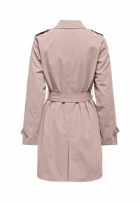 Trench-coat rose clair avec une taille ceinturée, des manches longues, des épaulettes et une texture de tissu lisse et légèrement brillante.
