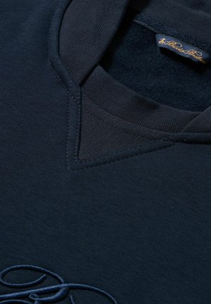 Marineblaue Poloshirt mit strukturiertem Kragen, detaillierter Naht und gesticktem Logo am Saum. Weicher Stoff mit glatter Oberfläche.