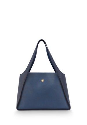 Donkerblauwe leren tote bag met een modern ontwerp, met schuine zijkanten, brede hengsels en een gouden embleem aan de voorkant.