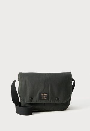 Dark green canvas messenger bag with a flap, two snap closures, and an adjustable strap; features a branded leather patch on the front.