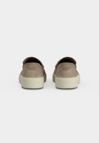 Paire de baskets beige en daim à enfiler avec semelles blanches en caoutchouc vues de dos sur fond uni.
