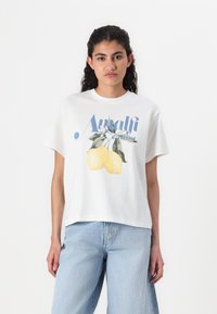 Hvid bomuld t-shirt med korte ærmer, der har et grafisk motiv af gule citroner og blå tekst "Amalfi Coast" på fronten.