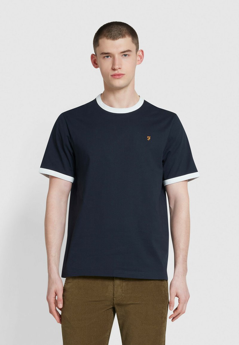 Maglietta blu navy con colletto e bordi delle maniche bianchi; presenta un piccolo logo arancione sul petto; realizzata in tessuto liscio e leggero.