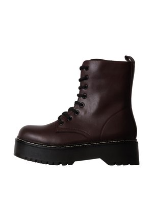 Bottine en cuir marron foncé avec semelle cramponnée épaisse noire et lacets noirs, profil latéral sur fond blanc.