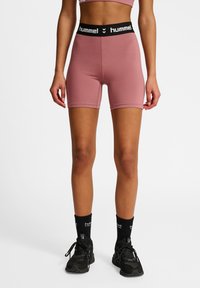 Roze sportshorts met een zwarte elastische tailleband met het "hummel" logo. Gemaakt van glad, rekbaar materiaal, met een lengte tot halverwege de dij.