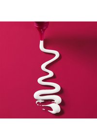 Pintura blanca formando espirales desde una botella rosa, creando una línea ondulante sobre un fondo rosa vibrante. Textura suave, acabado brillante y colores vivos.