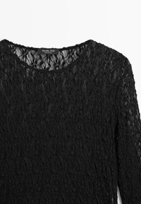 Black lace long-sleeve top with a round neckline. Features intricate floral patterns and a delicate texture. Label visible at the neckline.