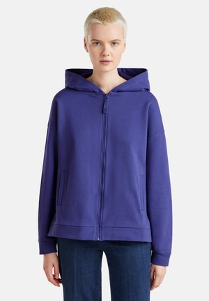 Haut de survêtement zippé violet en mélange de coton, doté d'une grande capuche, de poches avant et d'une coupe décontractée. Texture lisse avec des poignets côtelés.