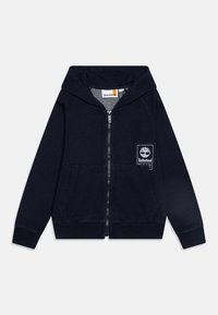 Jūras spēku kreisās puses kabatā zips ir izgatavots no kokvilnas, tam ir balts Timberland logo uzšuvums uz kreisās krūtis un ribotās aproces.