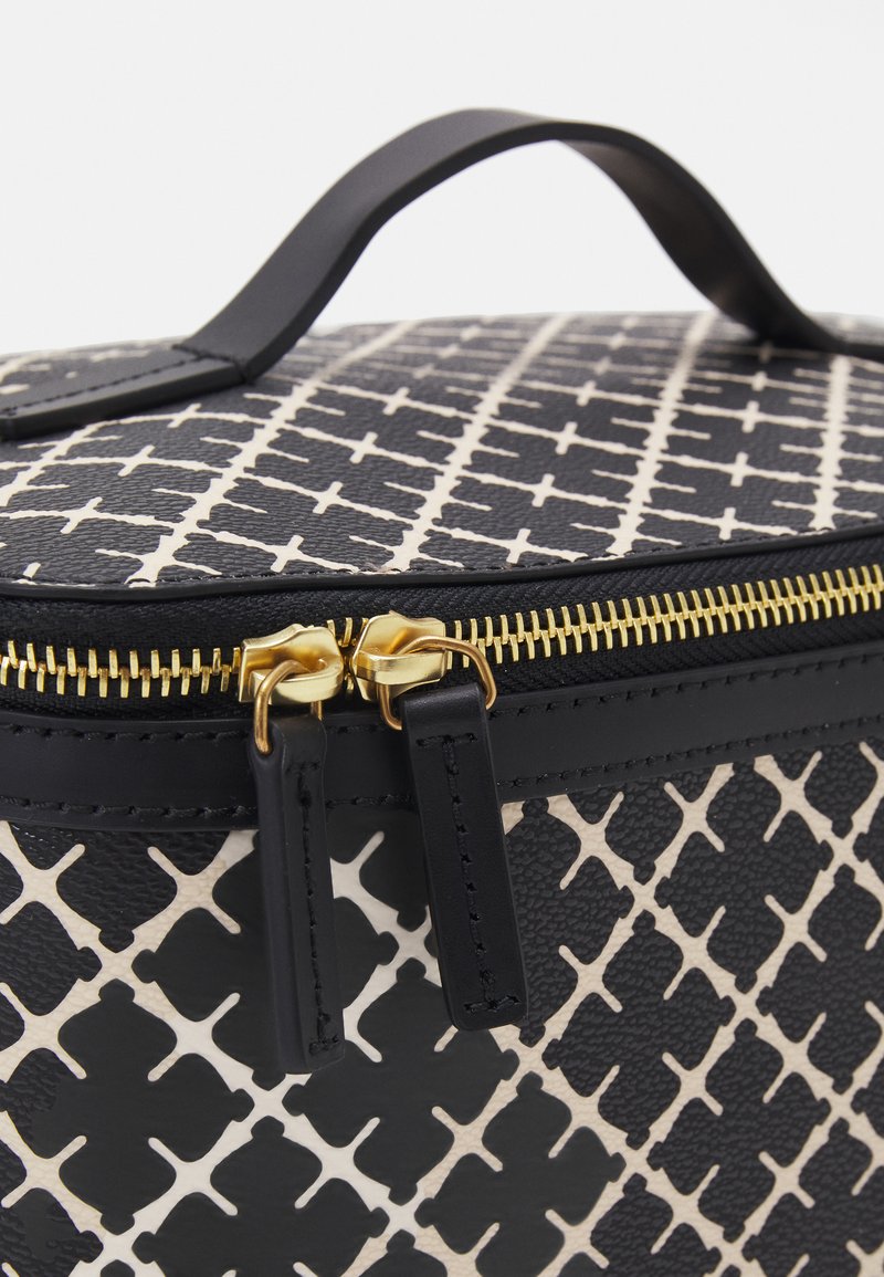 Round cosmetic bag with a black and white diamond pattern. Features a top handle, gold zipper, and textured material.